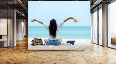 Lifestyle freelance woman raise arms relax after using laptop working on the beach.  Asian people success and together your work pastime and meeting conference on internet in holiday Wall mural